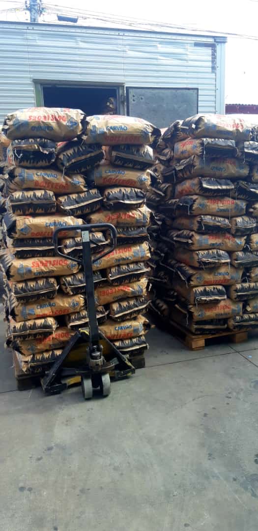 Paletes com sacos de carvão no depósito Carvão Dois Leões